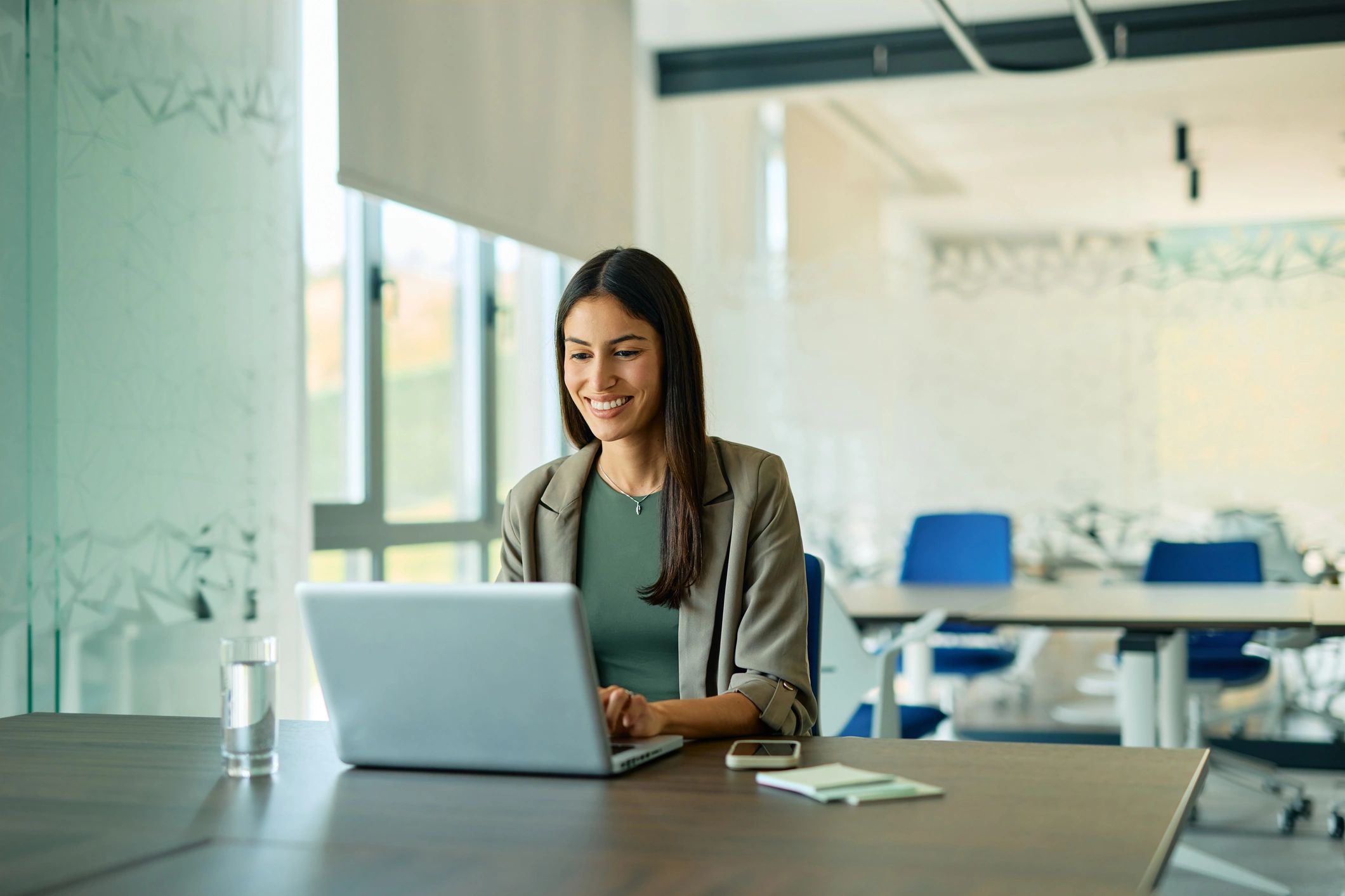 Administrative professional working on a laptop in an office