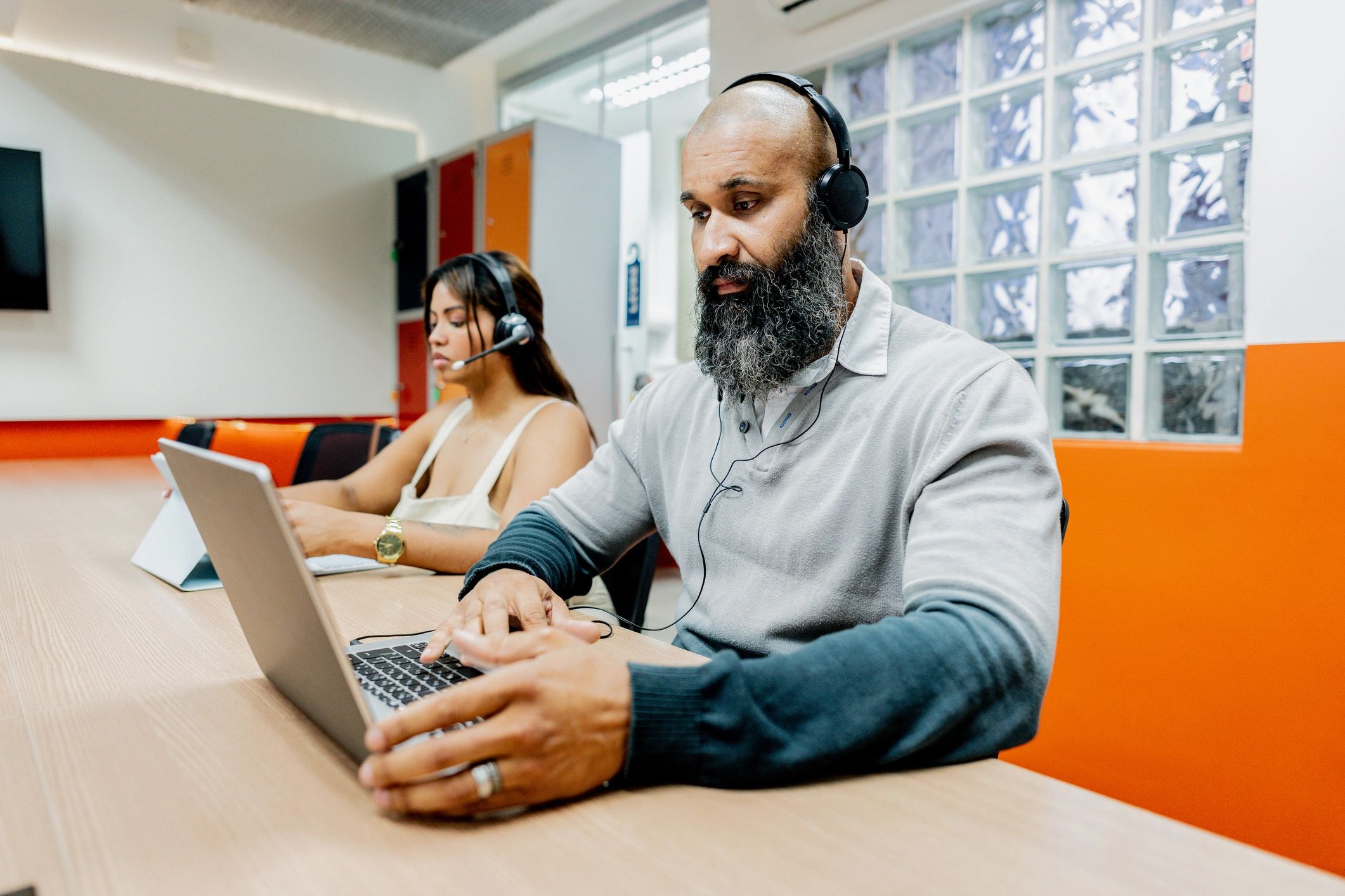 Customer support representative wearing a headset at a workstation