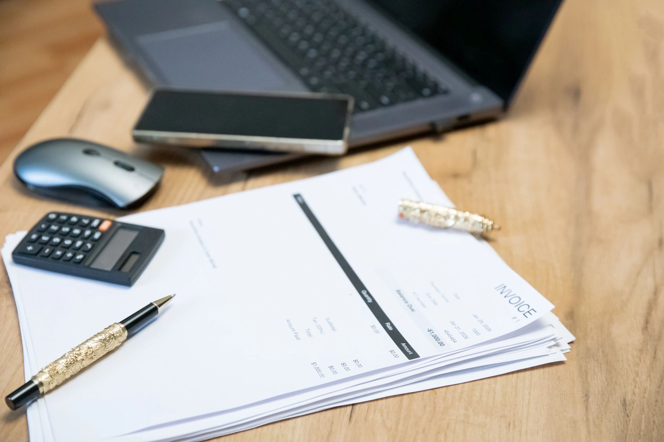 Invoices and calculator on a desk representing billing and finance operations